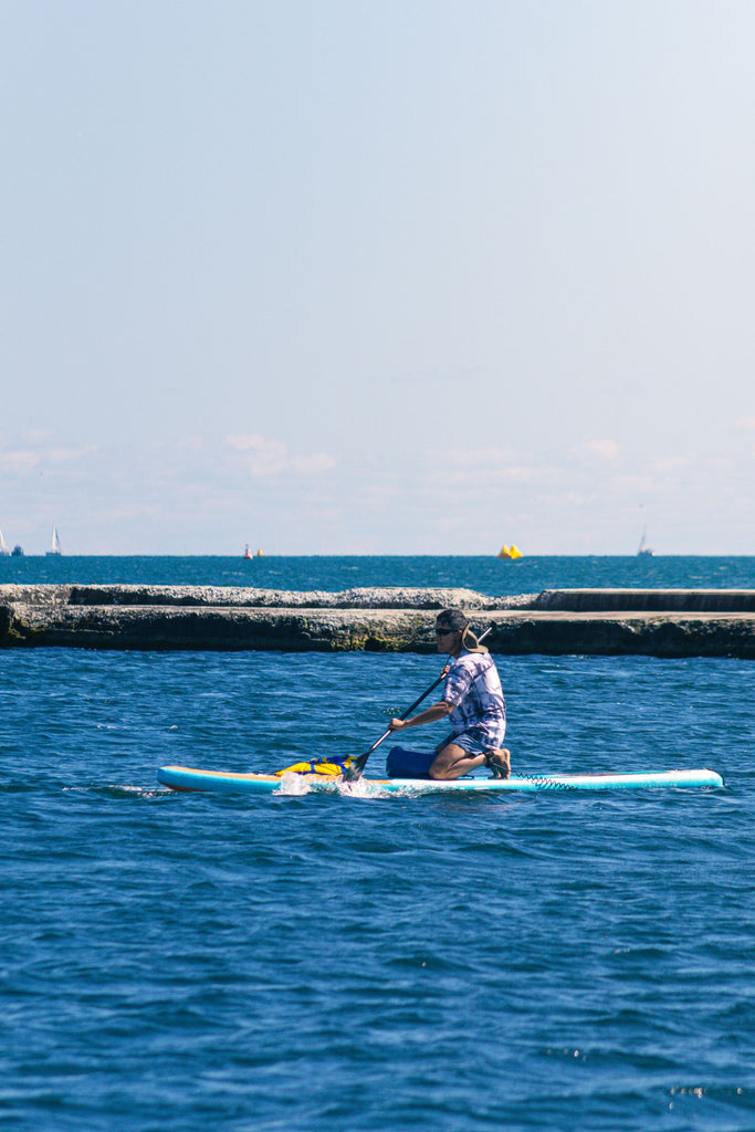 Paddle boarder on a calm Canadian lake on a sunny day